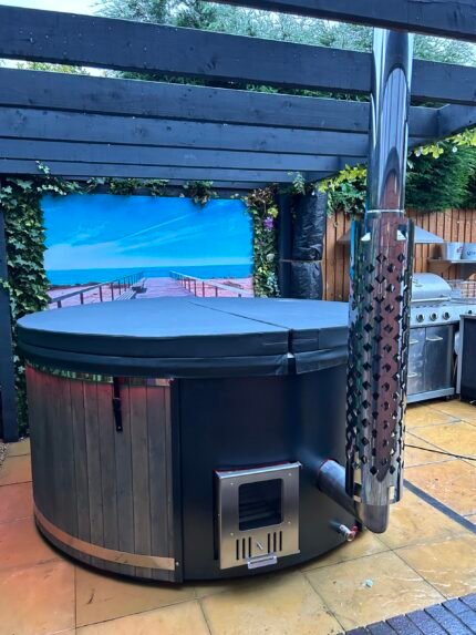 Brit Hot Tubs - Elevate Your Outdoor Oasis with the Luxurious SOLARA Deluxe Fiberglass Hot Tub Imagine stepping into a warm, soothing sanctuary right in the heart of your backyard. Introducing the SOLARA Deluxe Fiberglass Hot Tub – a stunning 4-6 seater designed to transform your outdoor living experience into a private oasis of pure relaxation and indulgence. Priced at £4,700 this exceptional hot tub is the perfect blend of luxury, comfort, and style, offering an unparalleled spa experience that you can enjoy anytime. Whether you're seeking a tranquil retreat for personal rejuvenation or a gathering place to create unforgettable memories with loved ones, the SOLARA is the ultimate investment in your well-being and outdoor lifestyle. SOLARA - DELUXE FIBERGLASS HOT TUB - Compact and Spacious Design With a compact diameter of 180 cm and an inside height of 90 cm, the SOLARA hot tub provides ample space for you and your guests, without overwhelming your outdoor setting. The ergonomic benches, standing 30 cm high and 33 cm wide, are designed for maximum comfort, allowing you to sink in and fully immerse yourself in the warm, soothing waters. Premium Fiberglass Construction Crafted from high-quality fiberglass, the SOLARA hot tub boasts a sleek, modern finish that's not only stylish but also incredibly durable and easy to maintain. Personalize the look by choosing from a range of interior colors, including Blue, White/Cream, or Grey, to seamlessly blend with your outdoor decor. Efficient and Eco-Friendly Heating At the heart of the SOLARA lies a stainless steel wood-burning oven with a flue, providing efficient and sustainable heating. This impressive system allows you to enjoy warm, relaxing waters quickly, without the long wait times typically associated with hot tub heating. Embrace the rustic charm of wood-fired heating while contributing to a more eco-friendly lifestyle. SOLARA - DELUXE FIBERGLASS HOT TUB - Advanced Relaxation Features Elevate your experience with the SOLARA's advanced hydrotherapy features. Indulge in the gentle caress of 10-12 air jets, releasing soothing bubbles that massage your body, and the targeted relief of 6 powerful hydro jets, designed to soothe muscle tension and promote deep relaxation. Set the perfect mood with the single LED light, featuring 4 color options to enhance your evening soaks. Customizable Aesthetics Personalize your SOLARA hot tub to reflect your unique outdoor style. Choose from elegant Fired and Stained Grey or Brown Thermowood cladding, with a 25 mm wall thickness, to create a harmonious look. Elevate the visual appeal further with side artwork illuminated by LED lights, selecting from designs like a horse, palm, or forest tree. Convenience and Comfort The SOLARA hot tub comes equipped with thoughtful features that prioritize your comfort and enjoyment. Relax under the insulated cover lid, which helps retain heat and keep your hot tub clean when not in use. Maintain crystal-clear water with the built-in filtration system, and keep your favorite refreshments close at hand with the convenient side drinks shelf. Unlock Your Personal Oasis of Relaxation Elevate your outdoor living experience and transform your backyard into a haven of luxury and tranquility. The SOLARA Deluxe Fiberglass Hot Tub is more than just a purchase; it's an investment in your overall well-being, quality time with loved ones, and the creation of cherished memories that will last a lifetime. Don't settle for anything less than the ultimate in relaxation and entertainment. Order the SOLARA Deluxe Fiberglass Hot Tub today and unlock a world of unparalleled comfort and rejuvenation right in the comfort of your own home. SOLARA HOT TUB SPECIFICATIONS High quality fibreglass insert Wood cladding walls Internal wood fired heater  Internal width 180 cm  External width 200 cm  Capacity: 4-6 person Inside height 88 cm; External height 105 cm Water capacity: 1200 - 1300L Empty weight 200kg 1,5h – 2h heating time Insert insulated with polyurethane foam Glass heater door Stainless steel chimney 2m with a cap Chimney heat guard Hydro massage and air bubble system with 8 jets Air bubble system with 12 jets Underwater LED light 1 Mini LED lights  Exterior LED light stripe Insulated Thermo lid  2 drink holders - stainless steel Box stair Sand filter Stainless steel drain valve 40mm 24 months warranty Colour of fibreglass insert available : light blue, grey, light grey or cream Stainless steel wood burning oven ( AISI 304) 30 kW or (AISI 316) 30 kW Oven front colour: Stainless steel – Grey or Black Wall cladding: Pine Wood - thickness 20 mm, Thermo Wood - thickness 20 mm, UPVC - thickness 18mm, Cedar Wood - thickness 18 mm Wood cladding stain colours: Transparent Grey, Transparent Brown, Teak, and Black Insulated Thermo lid colours: grey or brown Do you have more QUESTIONS about SOLARA fibreglass hot tub? Contact our sales team now! Here you can find alternative hot tubs.